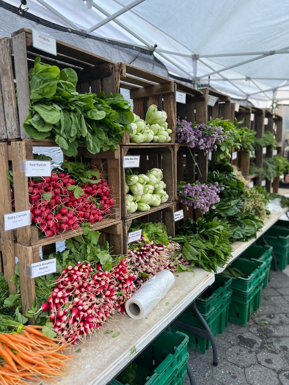 Fresh vegetables displayed in wooden crates at a market